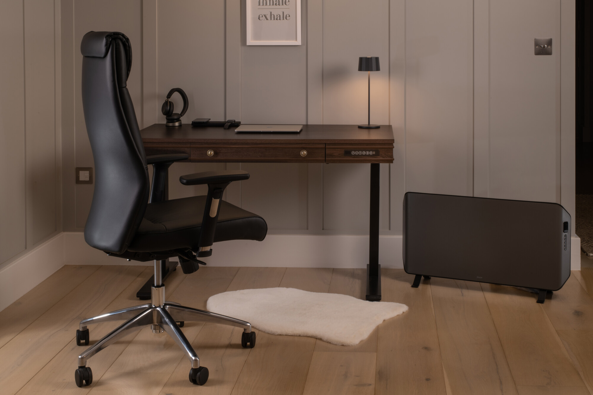 Mahagony effect height adjustable desk paired with an all-black faux leather ergonomic desk chair. 